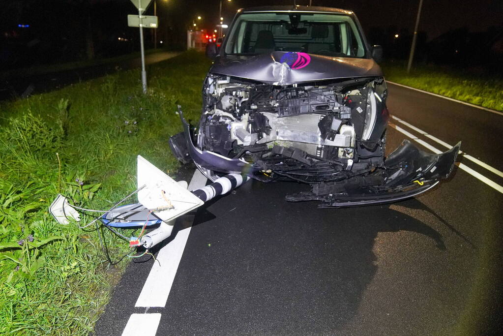 Bestelauto rijdt verkeerslicht uit de grond