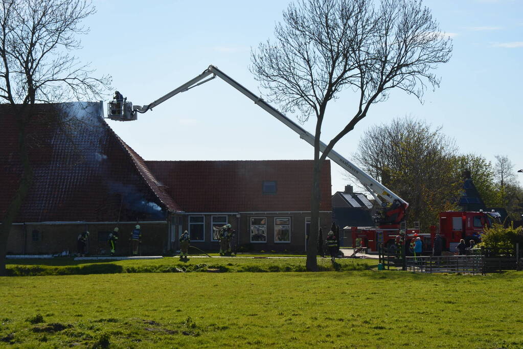 Brand in dak van woonboerderij