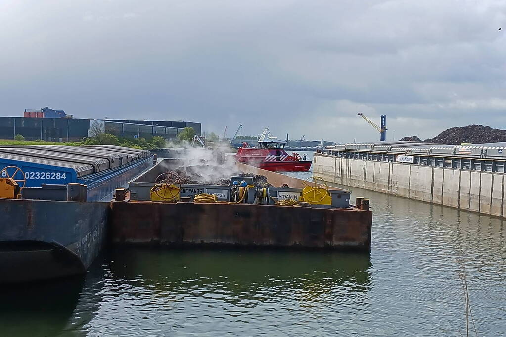 Brandweerboot inspecteert dampende duwbak