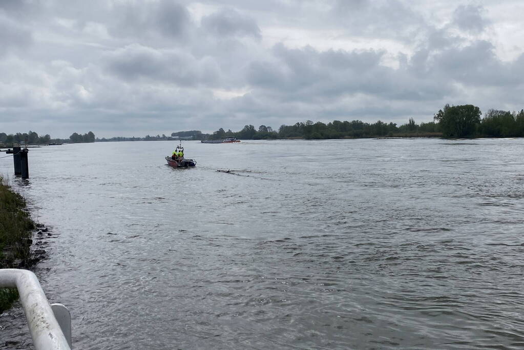 Brandweerboot sleept boom uit rivier