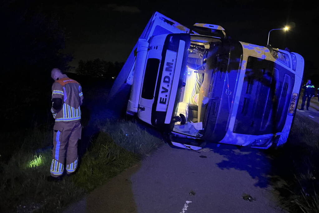 Vrachtwagen ramt boom en belandt op zijkant in sloot