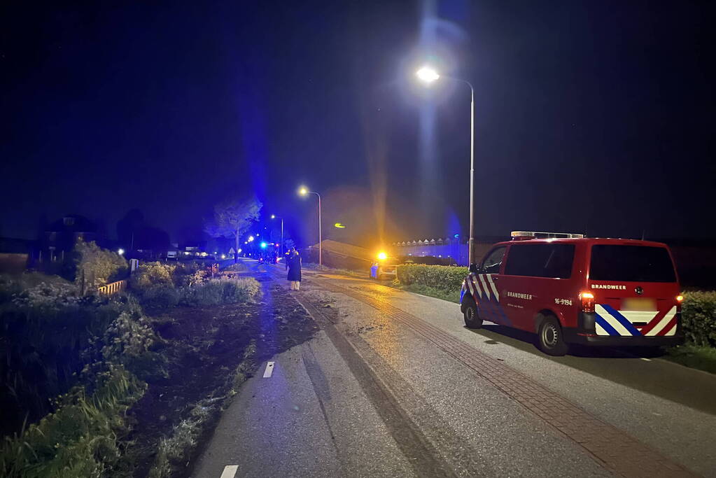 Vrachtwagen ramt boom en belandt op zijkant in sloot