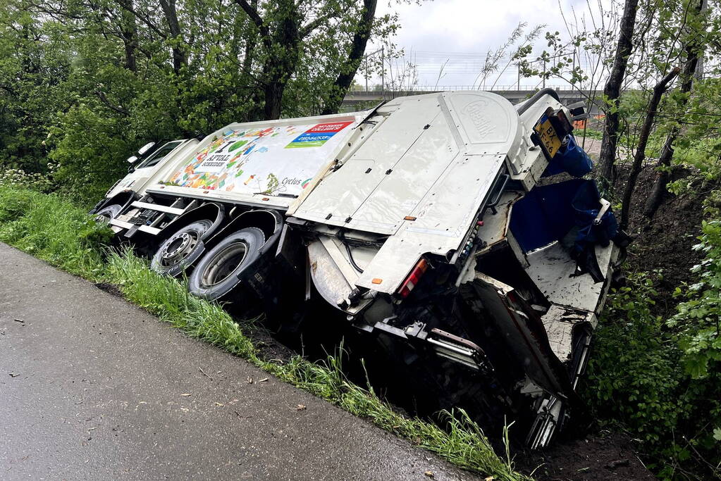 Vuilniswagen glijdt de bosschages in