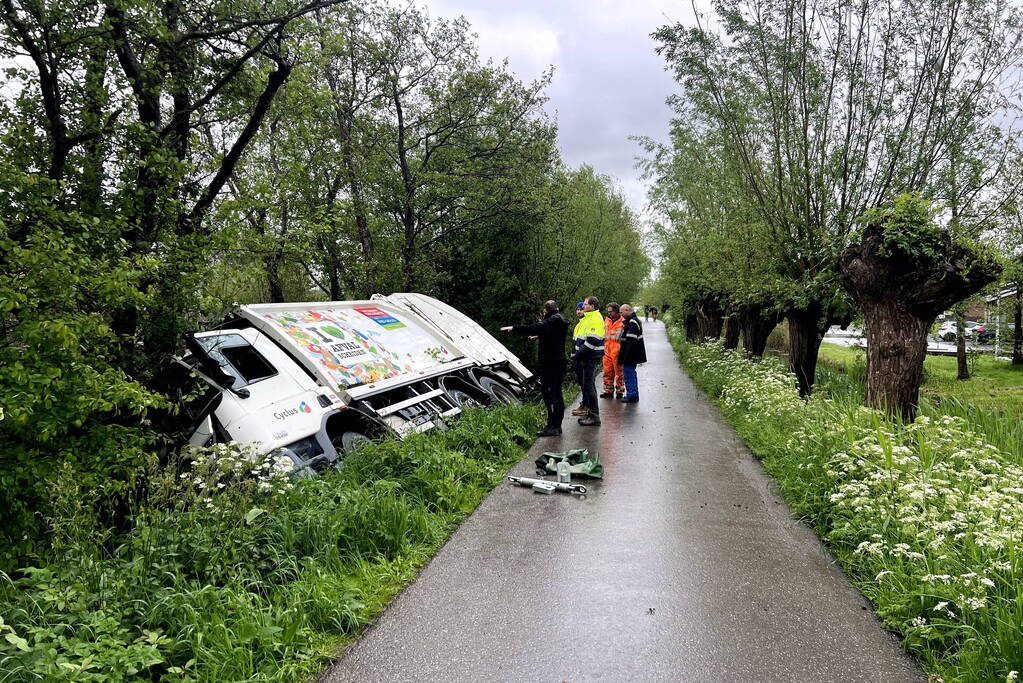 Vuilniswagen glijdt de bosschages in