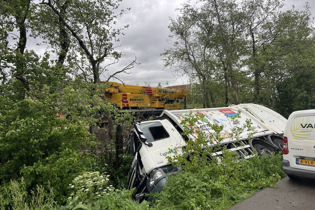 Vuilniswagen glijdt de bosschages in