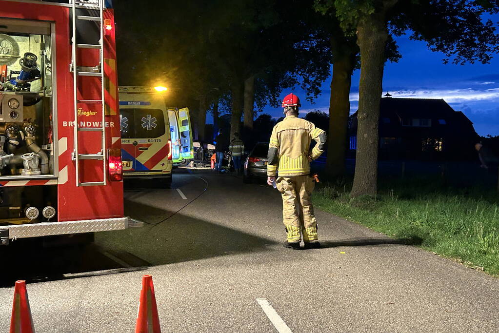 Automobilist bekneld na botsing met boom