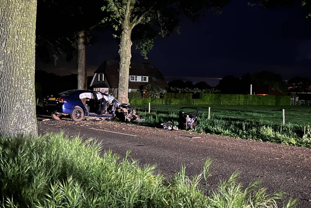 Automobilist bekneld na botsing met boom