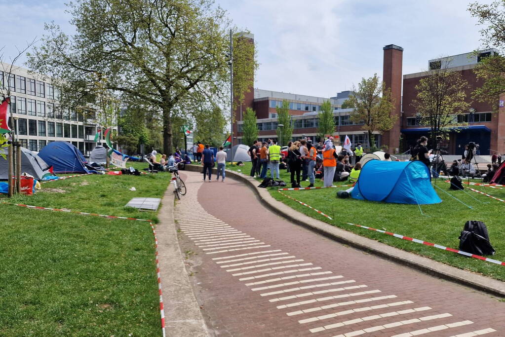 Studenten in tenten op grasveld bij UvA