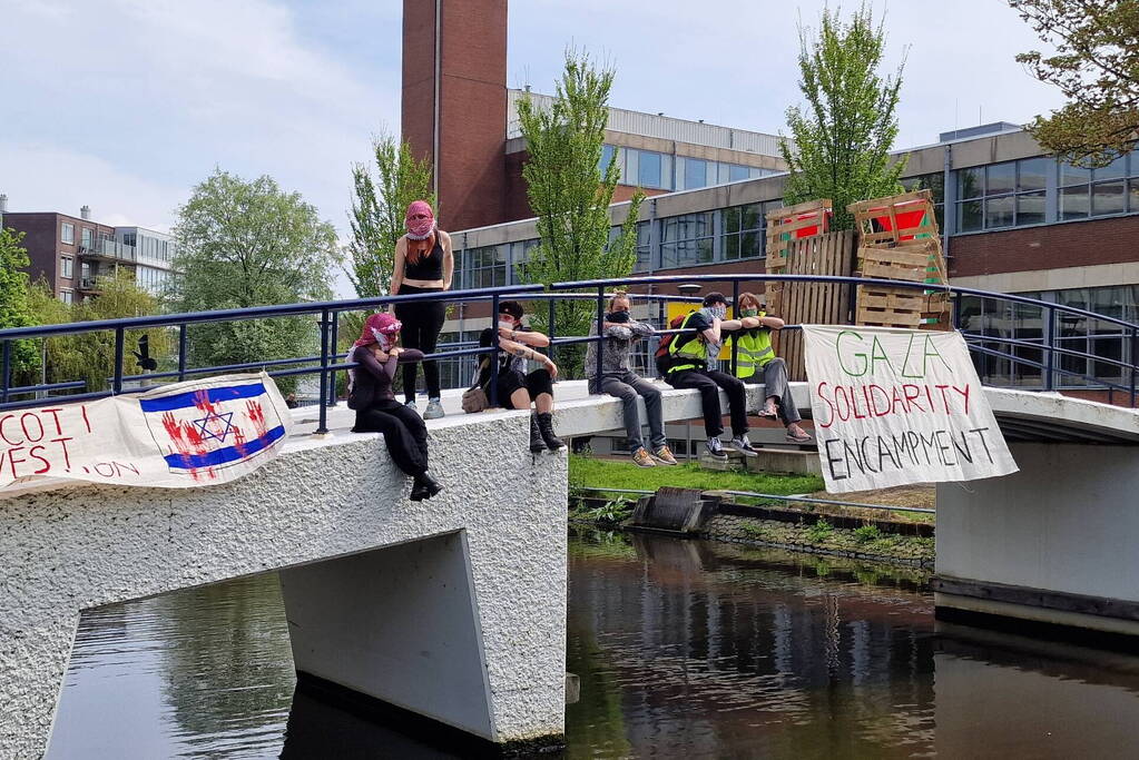 Studenten in tenten op grasveld bij UvA