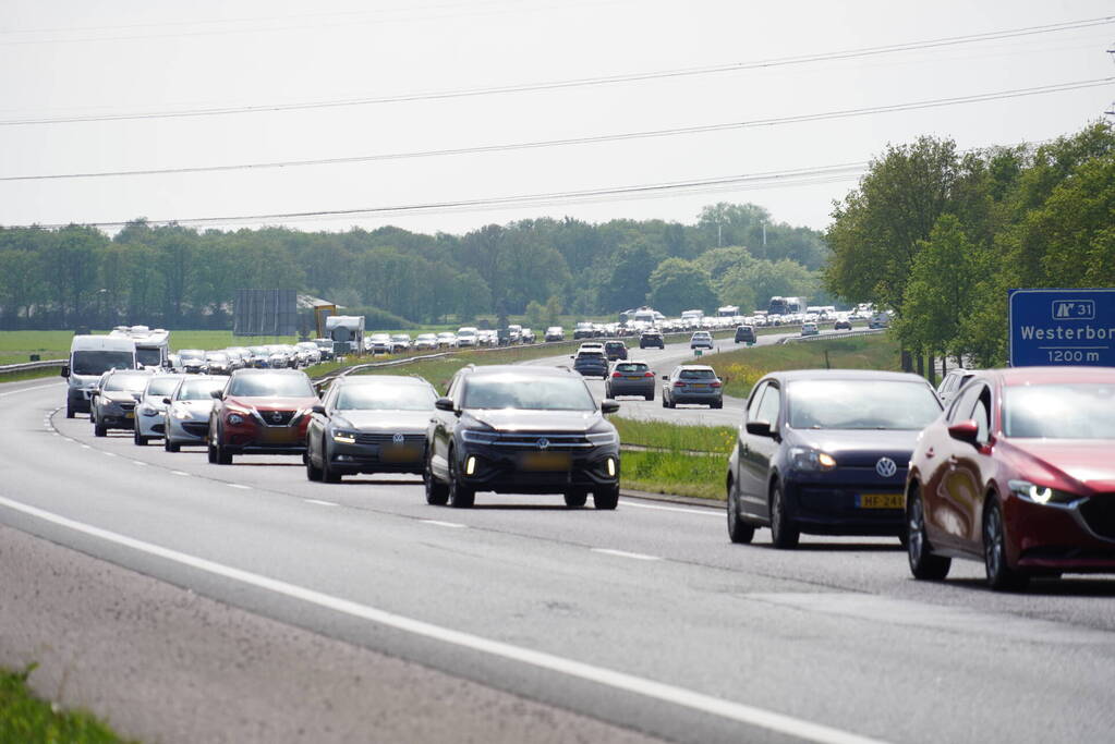 Vrachtwagen verliest band en veroorzaakt schade en file