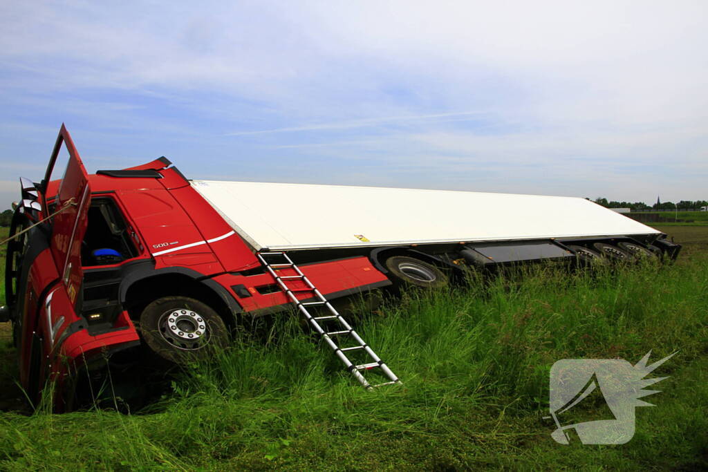 Vrachtwagen op zijn kant in sloot