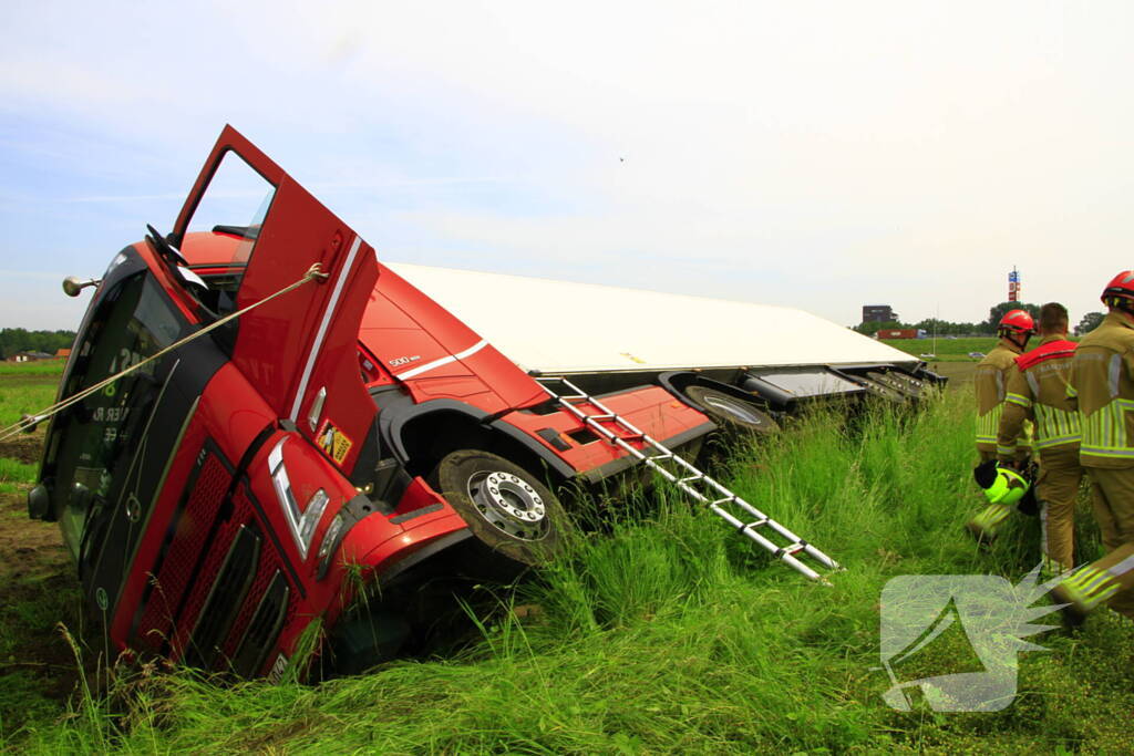 Vrachtwagen op zijn kant in sloot