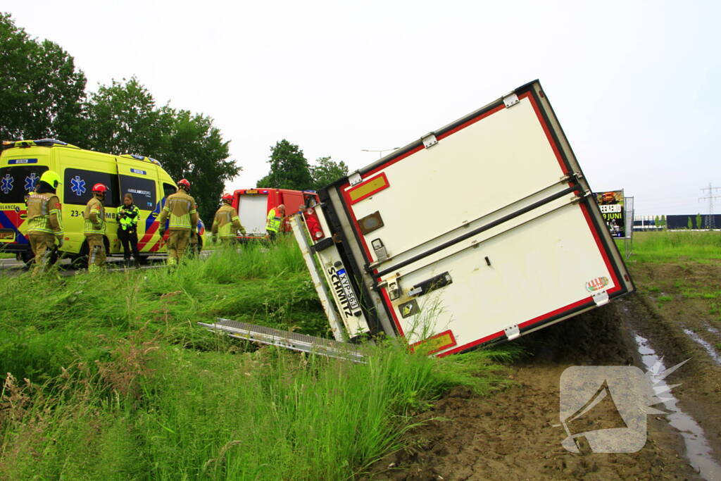 Vrachtwagen op zijn kant in sloot