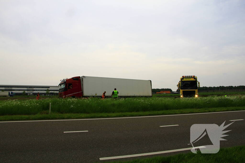 Vrachtwagen op zijn kant in sloot