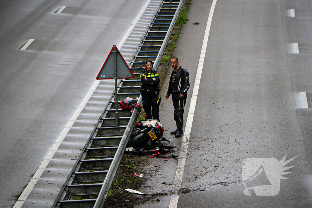 Motorrijder hard onderuit door water onder viaduct