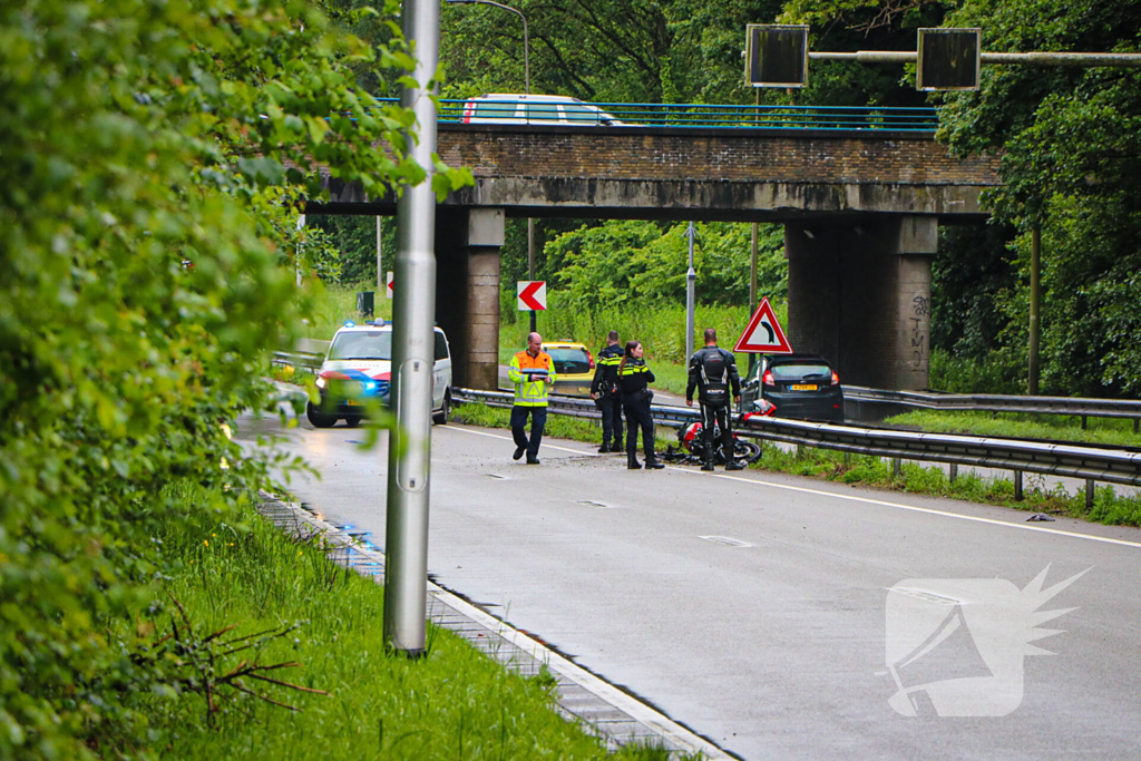 Motorrijder hard onderuit door water onder viaduct