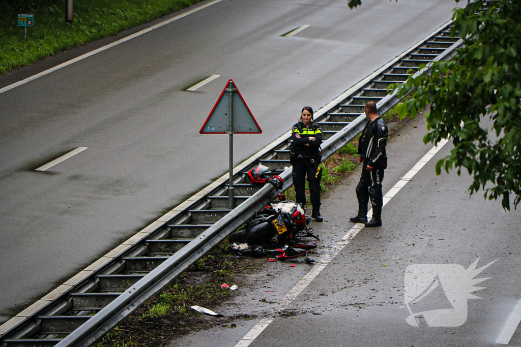 Motorrijder hard onderuit door water onder viaduct