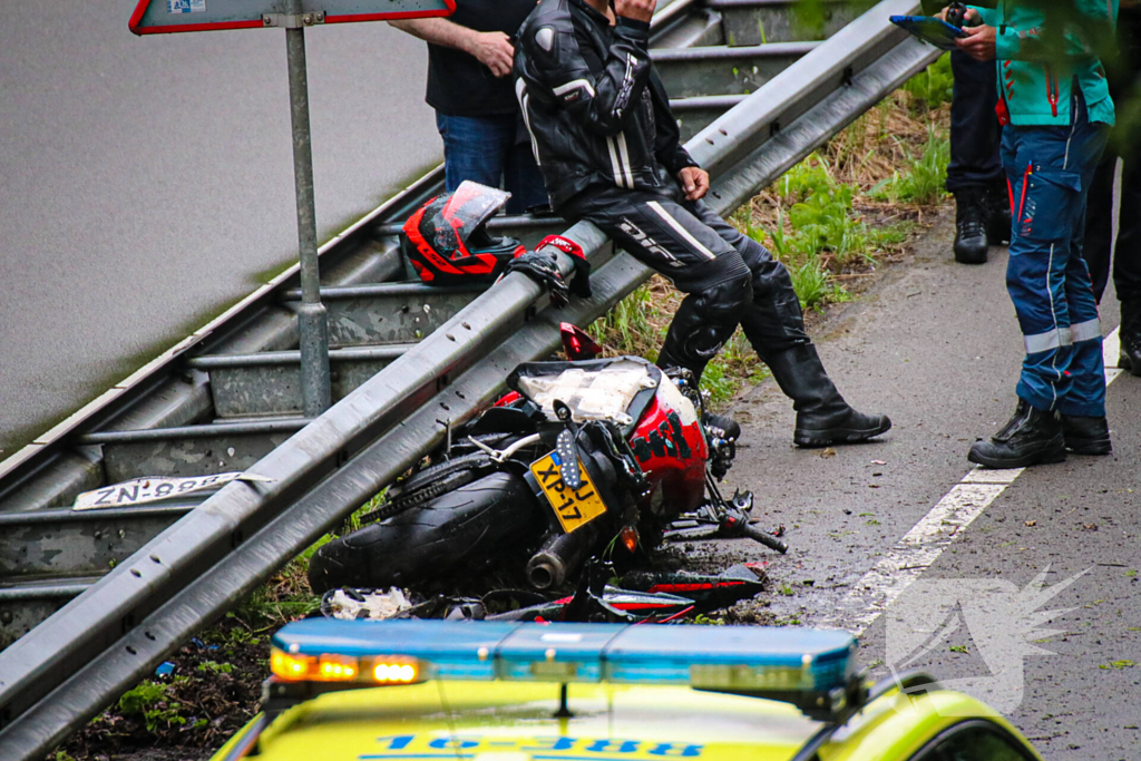 Motorrijder hard onderuit door water onder viaduct