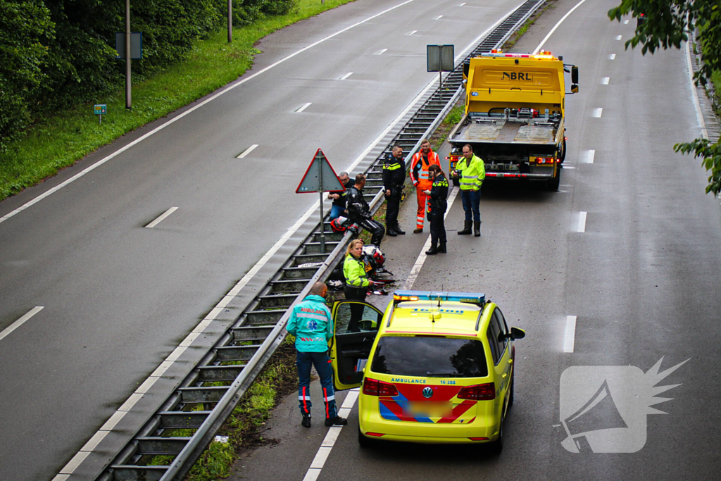 Motorrijder hard onderuit door water onder viaduct