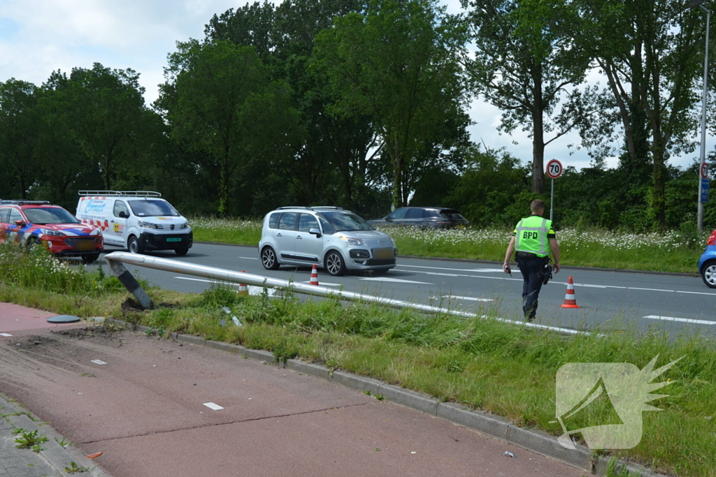 Automobilist rijdt tegen lantaarnpaal en hekwerk