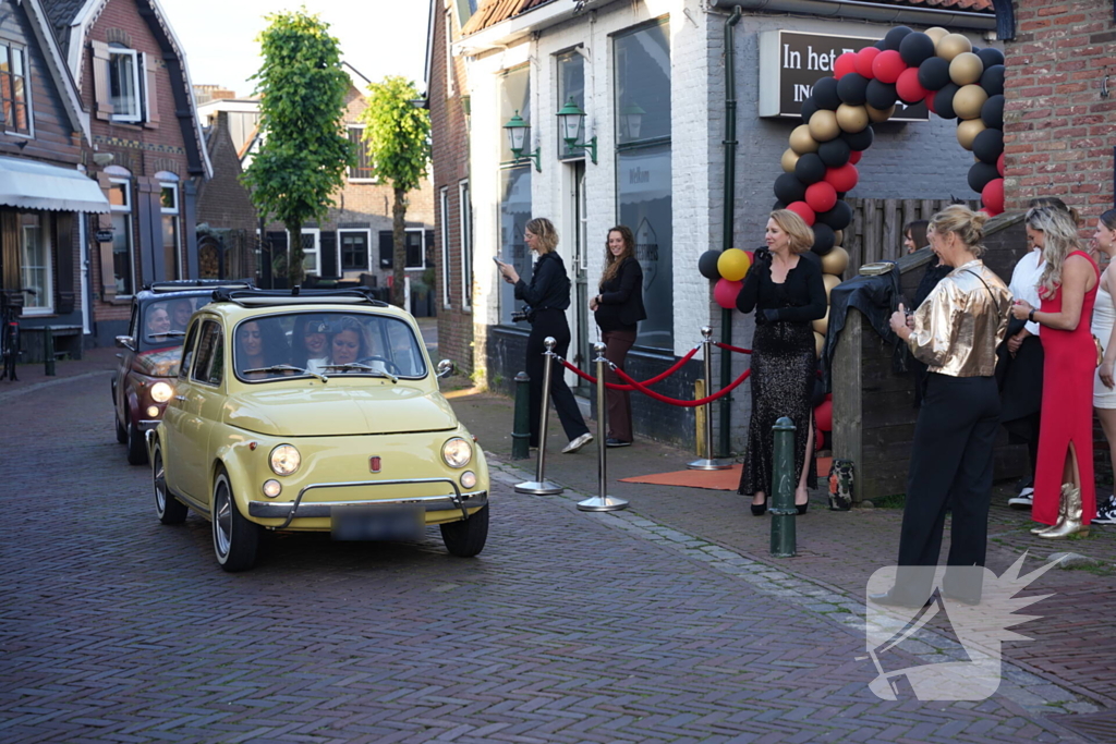 Leerlingen komen in bijzondere auto's aan bij examenfeest