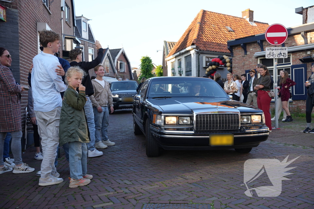 Leerlingen komen in bijzondere auto's aan bij examenfeest