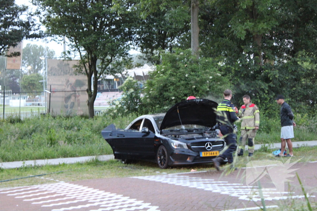 Brandweer blust brand in geparkeerde auto