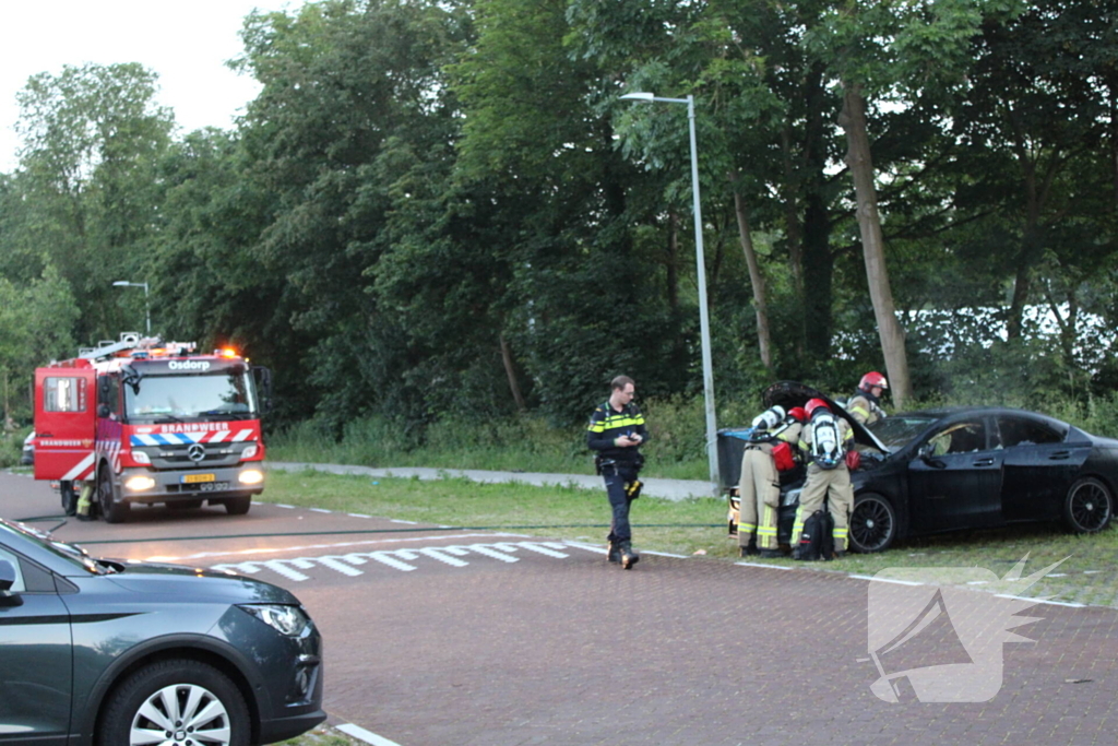 Brandweer blust brand in geparkeerde auto