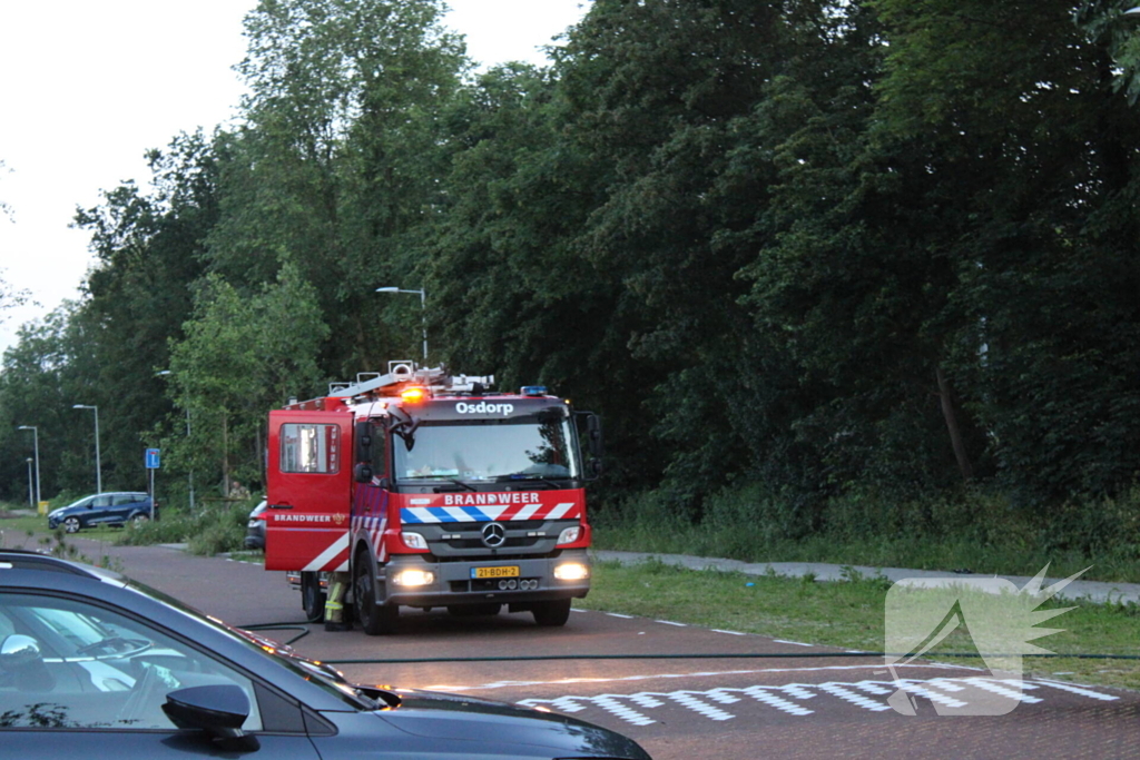 Brandweer blust brand in geparkeerde auto