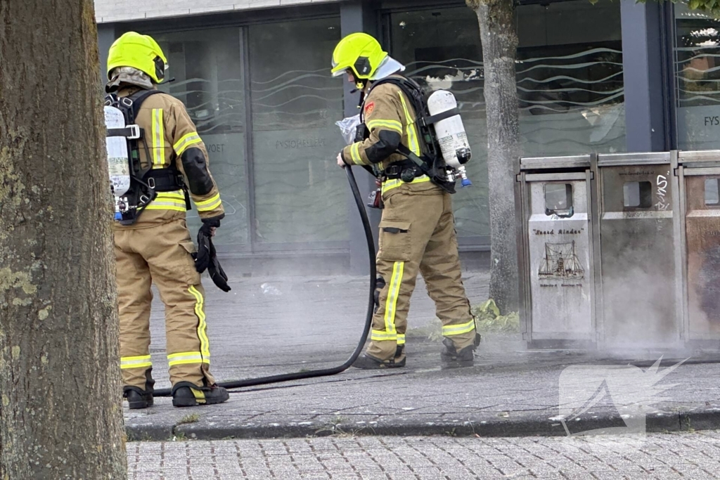 Brandweer blust brand in afvalbak