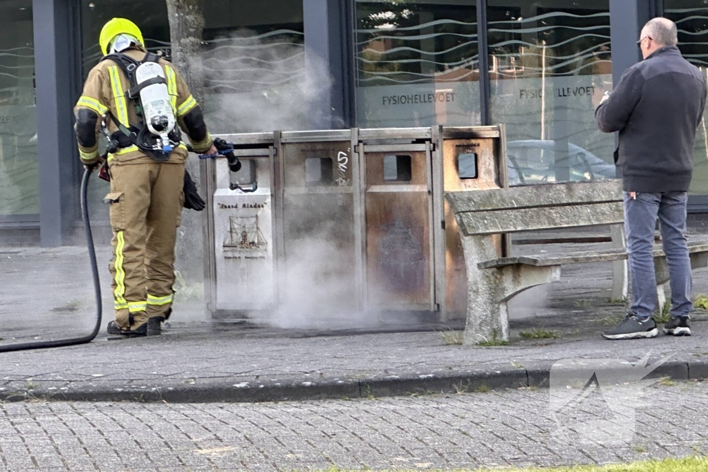 Brandweer blust brand in afvalbak