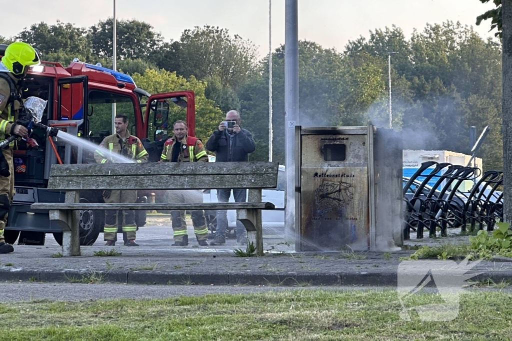 Brandweer blust brand in afvalbak