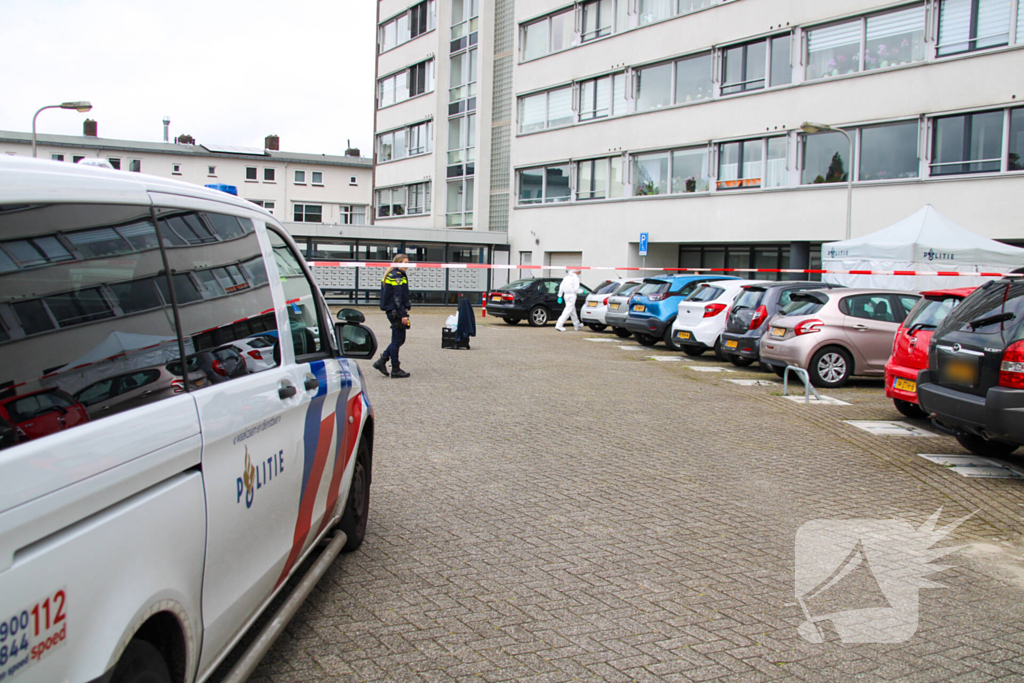 Forensisch onderzoek op parkeerplaats naast flatgebouw