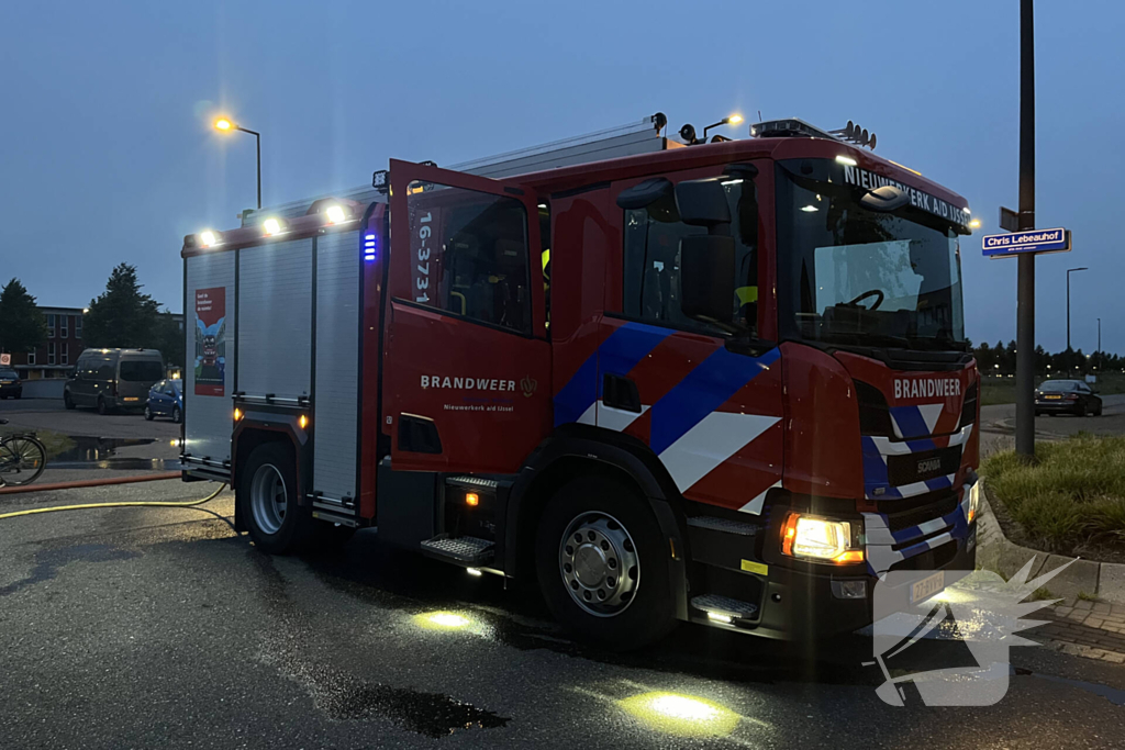 Brandweer blust in brand gestoken bouwkeet vol rommel