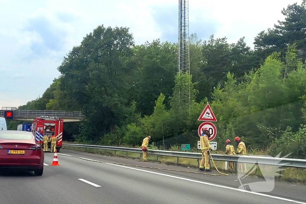 Brandweer blust brandende berm