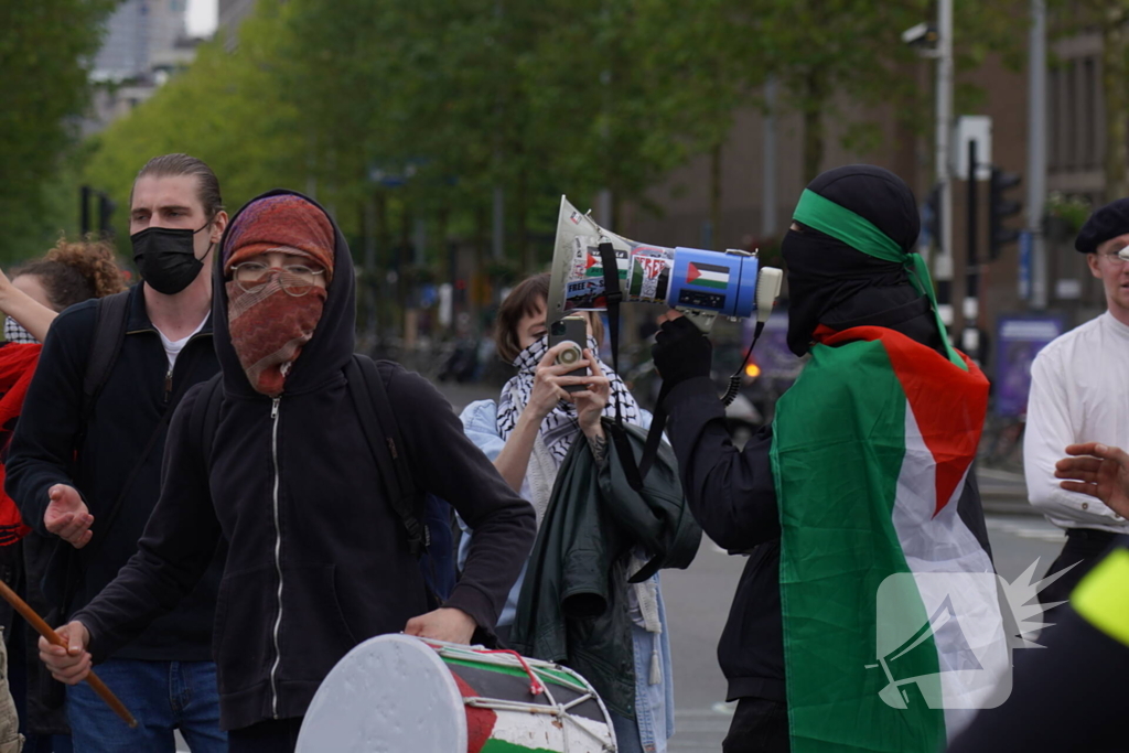 Demonstranten trekken persoon van scooter en slaan op auto's