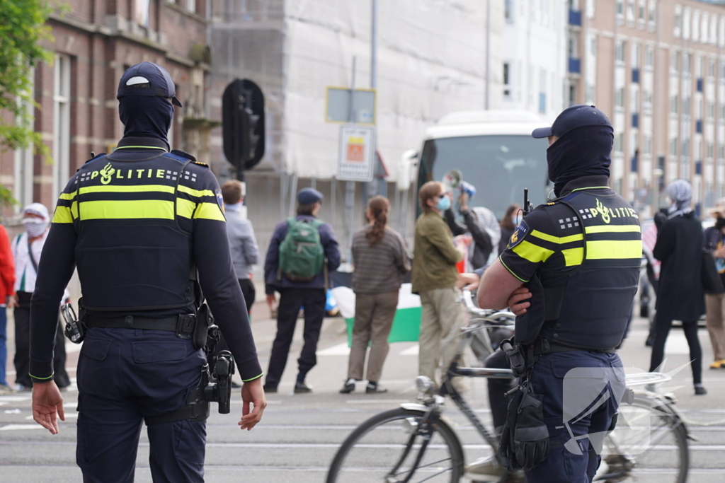 Demonstranten trekken persoon van scooter en slaan op auto's