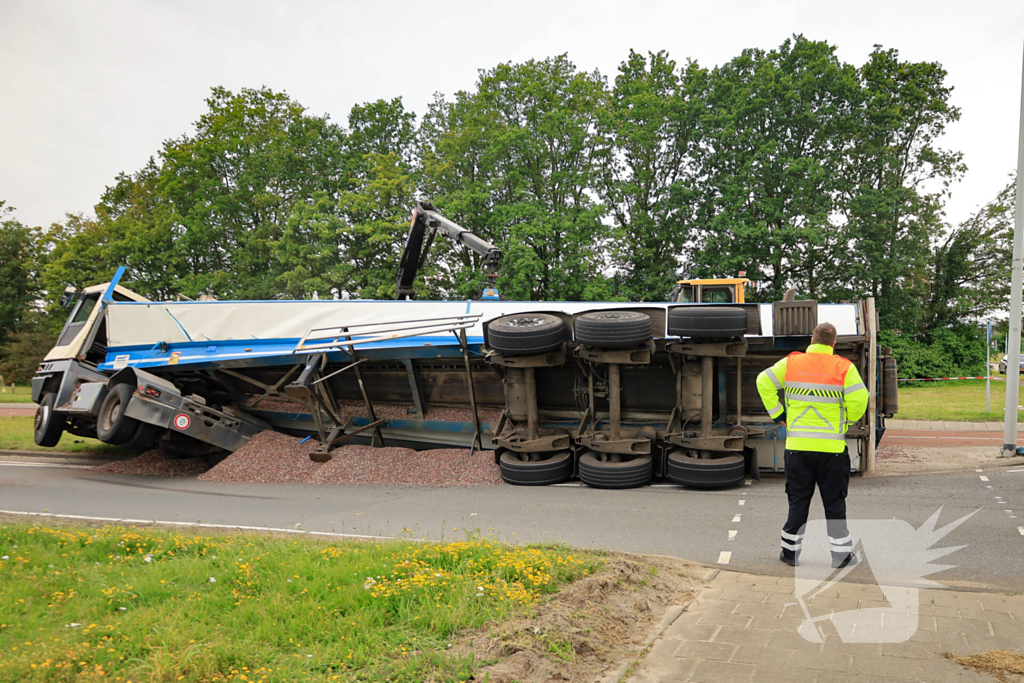 Oplegger geladen met grind kantelt