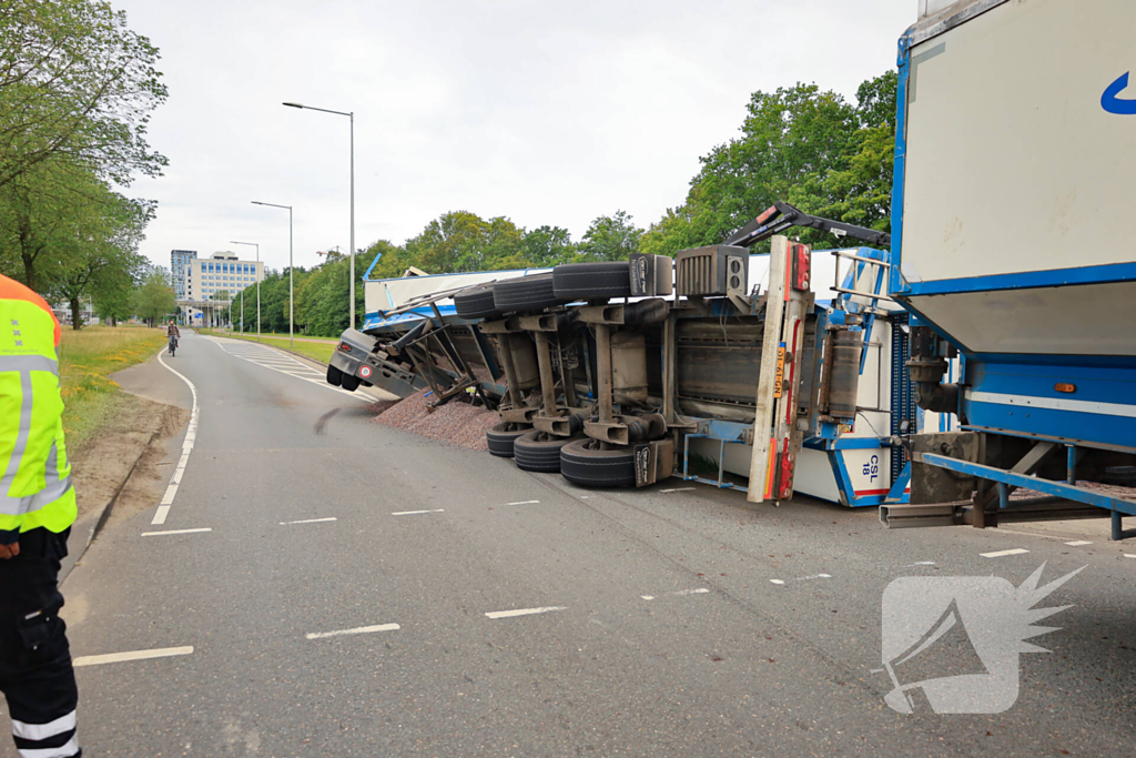 Oplegger geladen met grind kantelt