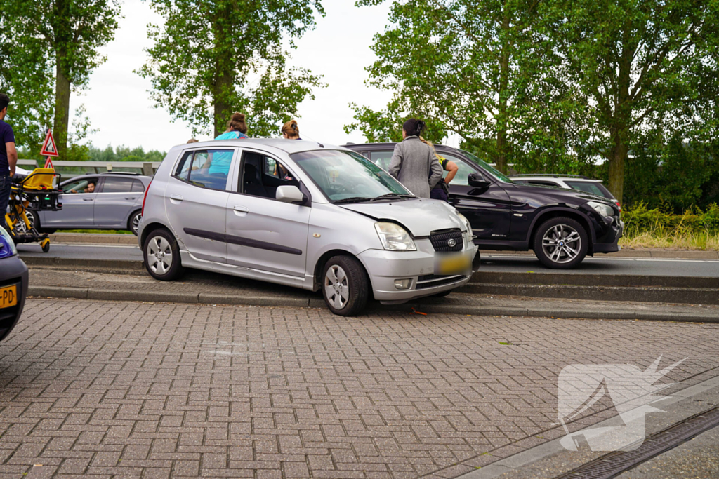 Motorrijder klemgereden tussen twee auto's