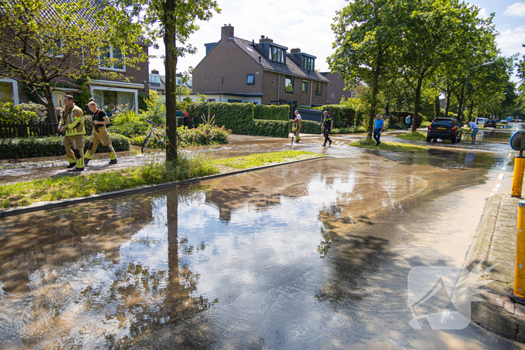 Straat blank door een gesprongen waterleiding