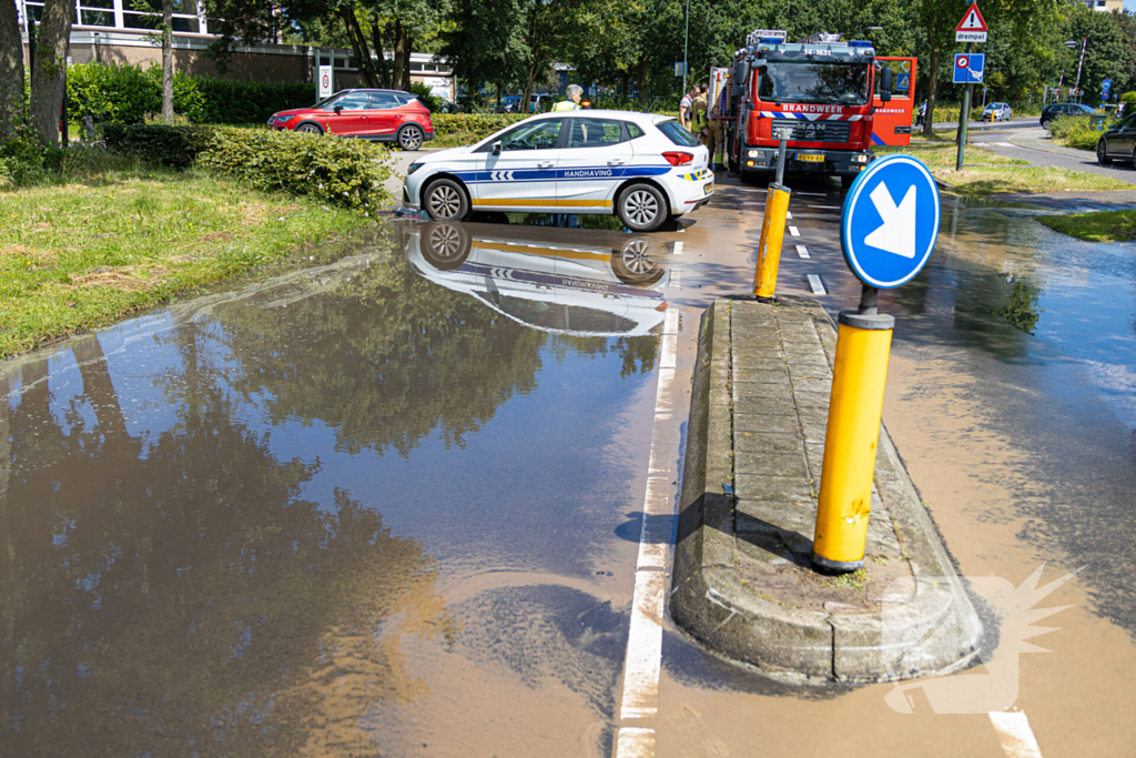 Straat blank door een gesprongen waterleiding