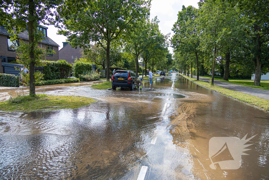 Straat blank door een gesprongen waterleiding