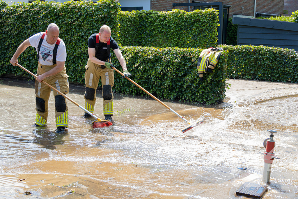 Straat blank door een gesprongen waterleiding