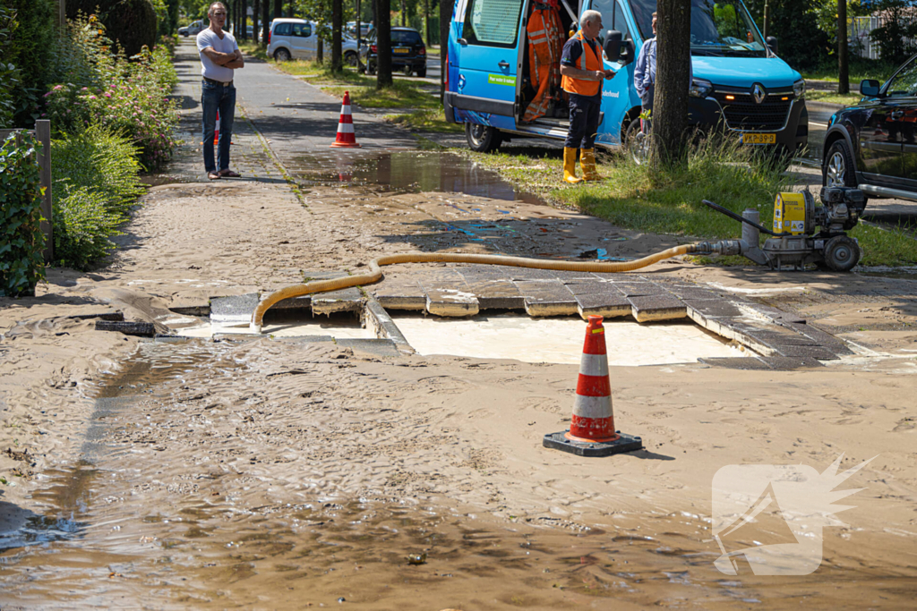 Straat blank door een gesprongen waterleiding