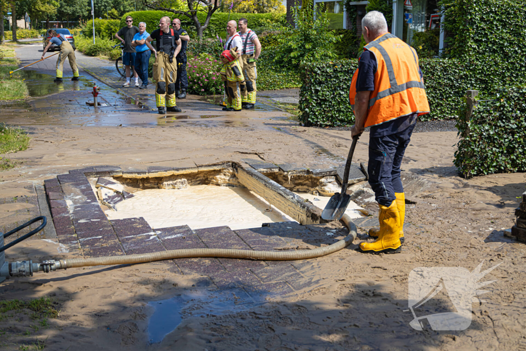 Straat blank door een gesprongen waterleiding