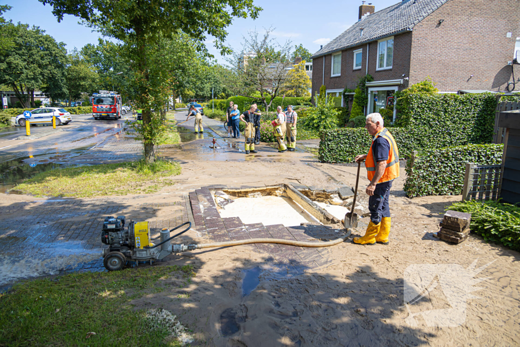 Straat blank door een gesprongen waterleiding