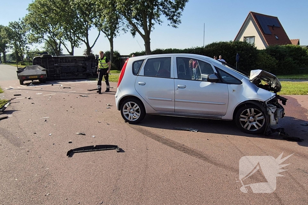 Bestelbus belandt op zijkant na frontale botsing op kruising, automobilist gewond