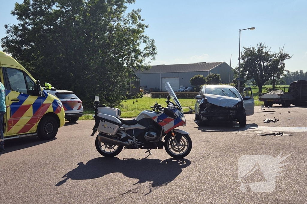 Bestelbus belandt op zijkant na frontale botsing op kruising, automobilist gewond