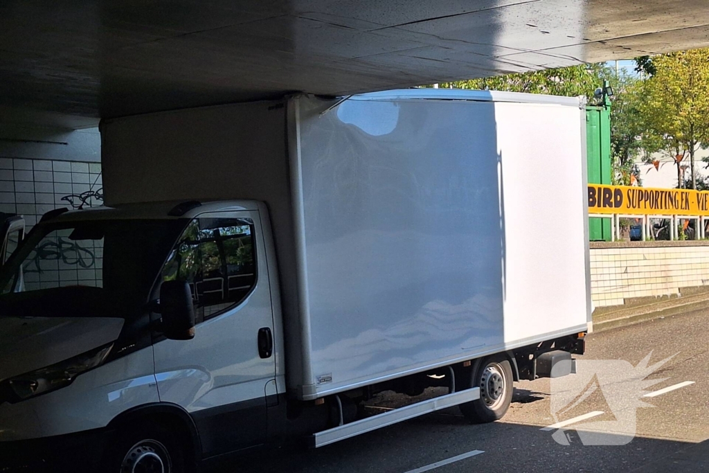 Bakwagen rijdt zich klem onder spoorviaduct